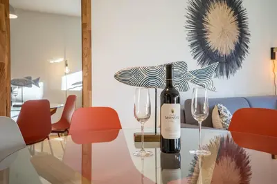 a bottle of wine on a glass table with two wine glasses at Historical Downtown Retreat Duplex by LovelyStay in Porto