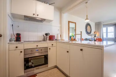 a kitchen with white cabinets and an oven at Historical Downtown Retreat Duplex by LovelyStay in Porto