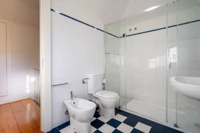 a white bathroom with a toilet and a sink at Historical Downtown Retreat Duplex by LovelyStay in Porto