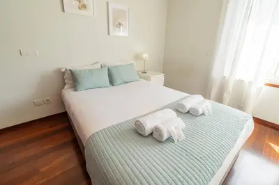 a bedroom with a large bed with towels on it at Modern Cedofeita by Hosty in Porto