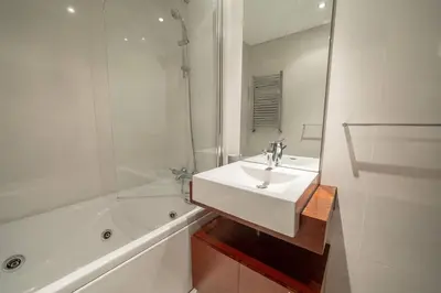 a white bathroom with a sink and a bath tub at Modern Cedofeita by Hosty in Porto