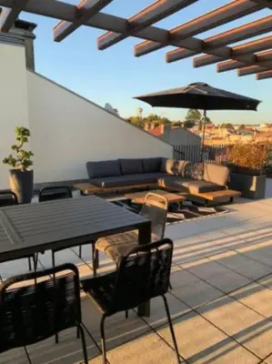 a patio with tables and chairs and an umbrella at Amazing Penthouse with a Terrace in Porto