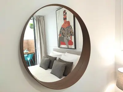a mirror in a room with a bed and a picture at Cais das Pedras Pátio Apartment - with washer and dryer machine in Porto
