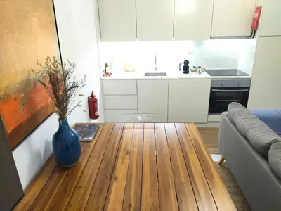 a living room with a vase on a wooden table at Cais das Pedras Pátio Apartment - with washer and dryer machine in Porto