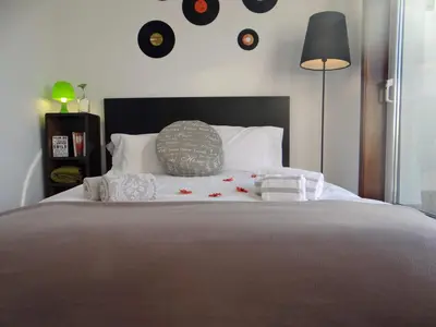 a bedroom with a large bed with a clock on the wall at Alegria Apartment Porto Downtown in Porto
