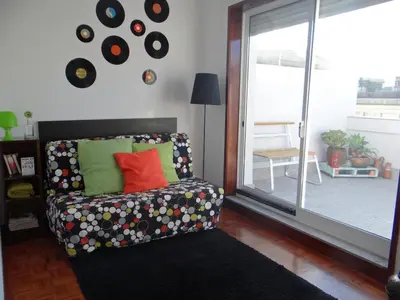 a living room with a couch and a large window at Alegria Apartment Porto Downtown in Porto