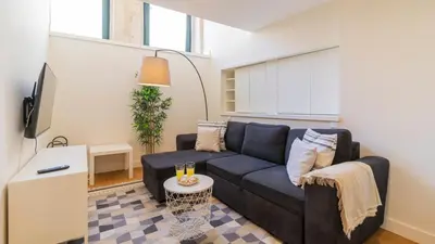 a living room with a couch and a table at Delightful Duplex by LovelyStay in Porto