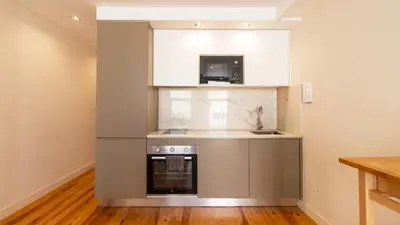 a kitchen with a stove and a sink and a microwave at Delightful Duplex by LovelyStay in Porto