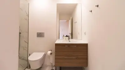 a bathroom with a toilet and a sink and a mirror at Delightful Duplex by LovelyStay in Porto