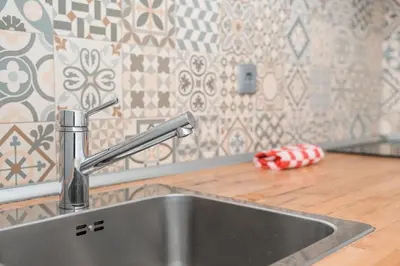 a stainless steel sink in a kitchen with tiles at GuestReady - Porto by Pilar Ridge in Vila Nova de Gaia