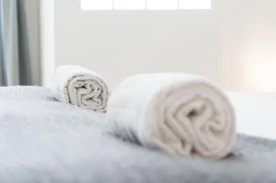 two rolls of towels sitting on top of a bed at GuestReady - Porto by Pilar Ridge in Vila Nova de Gaia