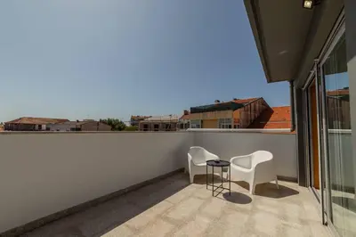 a balcony with two chairs and a table at Rooftop Stylish by Hosty in Porto