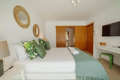 a bedroom with a large white bed with green pillows at Rooftop Stylish by Hosty in Porto