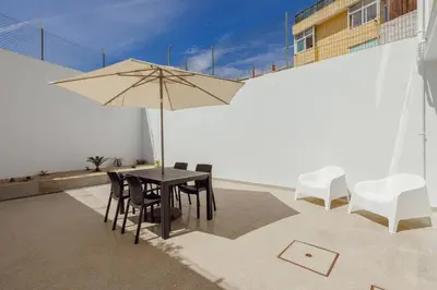 a table and chairs with an umbrella on a patio at Stylish Apartment With Terrace by Hosty in Porto