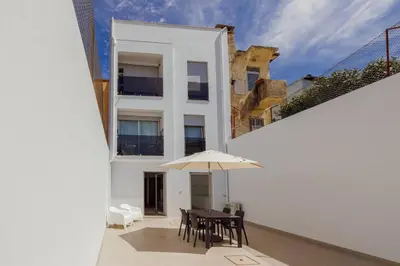 a white building with a table and an umbrella at Stylish Apartment With Terrace by Hosty in Porto