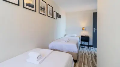 a hotel room with two beds and a table at Abadia by LovelyStay in Porto