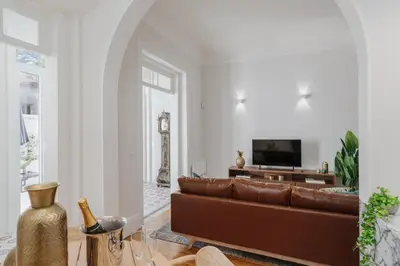 a living room with a brown couch and a tv at Romantic Luxury House w Captivating Outdoor Patio in Porto