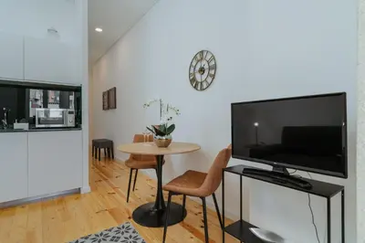 a living room with a large television and a table at Exclusive Charm House in Porto