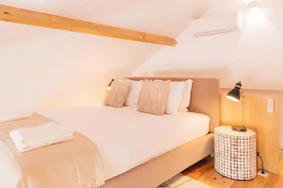 a bedroom with a bed with white sheets and a lamp at ORM - Cedofeita I Apartment in Porto