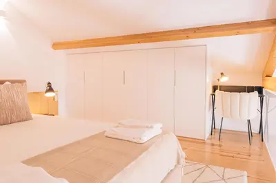 a bedroom with a white bed and a chair at ORM - Cedofeita I Apartment in Porto