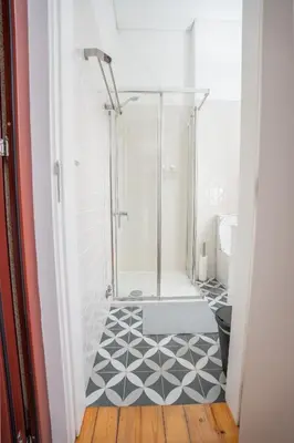a bathroom with a shower with a tile floor at Host Wise - Peaceful Amazing Apartment - Ace Location in Porto