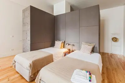two beds in a small room with wooden floors at bnapartments Loftpuzzle in Porto