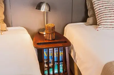 a table with a lamp on it next to two beds at bnapartments Loftpuzzle in Porto