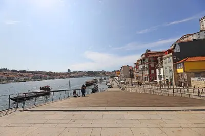 a pier next to a body of water with buildings at FLH Boavista Wooden Duplexes in Porto