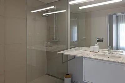 a bathroom with a shower and a sink and a mirror at FLH Boavista Wooden Duplexes in Porto
