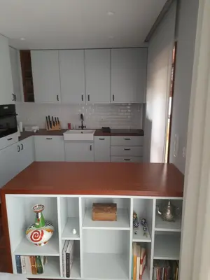 a kitchen with white cabinets and a wooden counter top at Portus Cale by LovelyStay in Vila Nova de Gaia