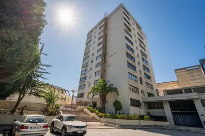 a building with two cars parked in front of it at Host Wise - Peaceful Sunny Flat - Ace Location in Porto