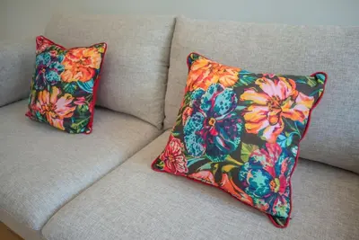 a pillow on a couch with a flower pattern at Truly Porto in Porto
