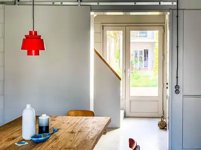 a room with a wooden table with a red lamp at Fabrica No Jardim in Porto
