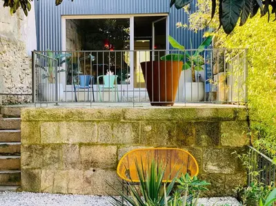 a bench sitting in front of a window with plants at Fabrica No Jardim in Porto