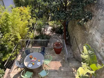 a patio with a table and chairs in a garden at Fabrica No Jardim in Porto