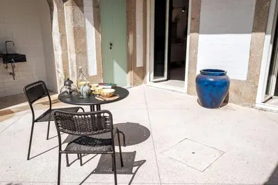 a patio with a table and chairs and a large blue vase at Gracy Porto in Porto