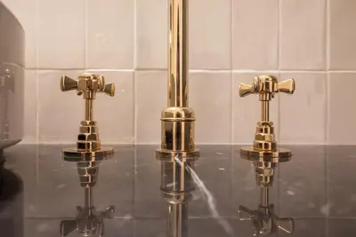 two gold faucets on a counter in a bathroom at Gracy Porto in Porto