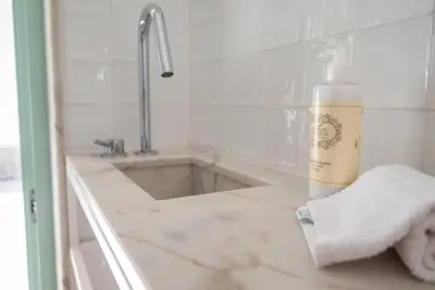 a bathroom with a sink and a bottle of soap on a counter at Gracy Porto in Porto