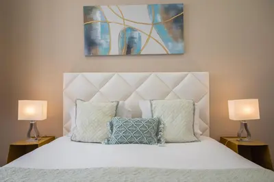 a bedroom with a white bed with two lamps at Mercadory Ribeira in Porto