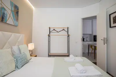 a bedroom with a large bed with towels on it at Mercadory Ribeira in Porto