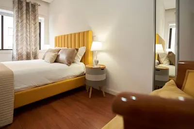 a bedroom with a bed with a yellow headboard at So Family Porto in Porto