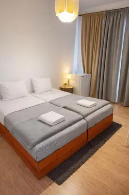 two beds in a room with yellow towels on them at Vikap Guest House in Porto