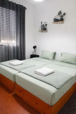 two beds in a room with blue sheets at Vikap Guest House in Porto