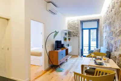 a living room with white shelves and a television at Netto City Vibes in Porto