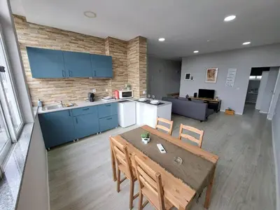 a kitchen and dining room with a table and chairs at Bolhão Apartment in Porto