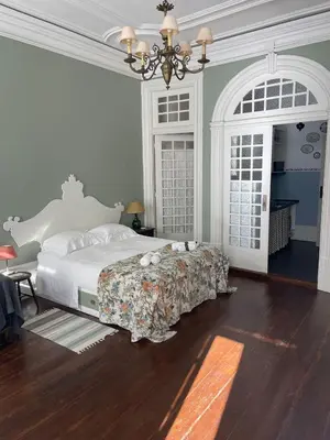 a bedroom with a bed and a chandelier at Estúdio Histórico século XIX com Varanda e Vistas para a Baixa in Porto