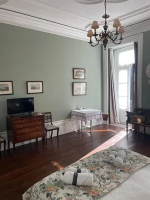 a living room with a table and a rug on the floor at Estúdio Histórico século XIX com Varanda e Vistas para a Baixa in Porto
