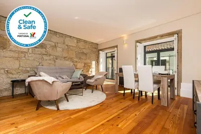 a dining room and living room with a stone wall at Trendy Porto in Porto