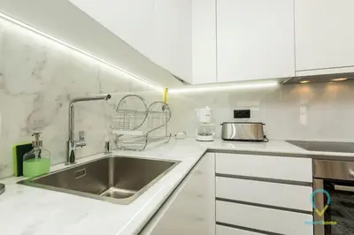a kitchen with a stainless steel sink and white cabinets at Trendy Porto in Porto