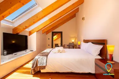 a bedroom with a large white bed and a tv at So Trendy Porto in Porto